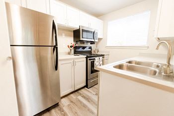 a kitchen with stainless steel appliances and white cabinets